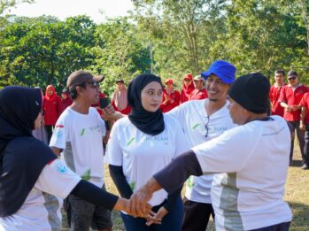 Participants in white and red attire engaging in outbound games, focusing on leadership and teamwork.