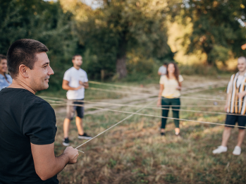 Participants playing a game with a thin white rope as part of our company's activities.