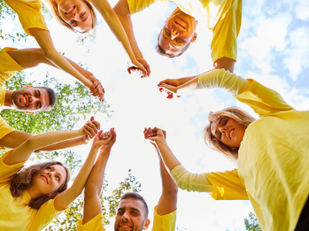 A group of people holding hands and celebrating, appearing victorious from an overhead view.