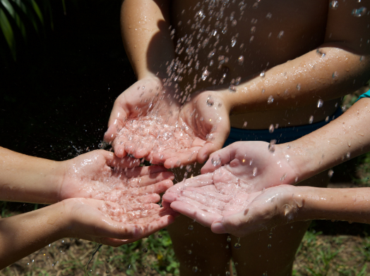 Children's hands are enjoying Clean Water .